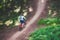 A cyclist in a helmet descends from the mountain on an orange bicycle, motion blur