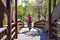 cyclist with helmet riding his mountain bike crossing a wooden brown bridge in a sunny day. Rider wears a red sweeter. Horizontal