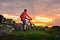 Cyclist with his Mountain Bike Looking at the Beautiful Sunset on Spring Rocky Trail. Extreme Sports and Adventure Concept.