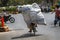 cyclist with a huge bag above human height moves along the road.