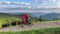 Cyclist man riding electric mountain bike outdoors along grassy trail in the mountains.