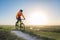 A cyclist in an orange hoodie rides a bike along a mountain path. The concept of extreme sports.