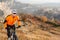 Cyclist in Orange Jacket Riding the Bike on the Rocky Trail. Extreme Sport Concept. Space for Text.