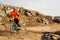 Cyclist in Orange Jacket Riding the Bike on the Rocky Trail. Extreme Sport Concept. Space for Text.