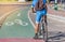 Cyclist parked bicycle on white bicycle lane sign with green asphalt road