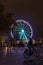Cyclist passing in front of the Ferris wheel of Bellecour in Lyon
