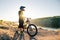 Cyclist Preparing for Riding the Mountain Bike on the Summer Rocky Trail at the Evening. Extreme Sport and Cycling.