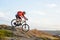 Cyclist in Red Jacket Riding the Bike Down Rocky Hill. Extreme Sport.