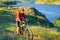 Cyclist in Red Jacket Riding Mountain Bike on the Beautiful Spring Trail above Blue River. Travel and Adventure Sport Concept