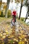 Cyclist ride through a puddle in the autumn park