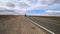 A cyclist rides on an asphalt road in the steppes of Mongolia.