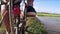 A cyclist rides on a narrow dirt trail separating flooded rice fields in rural Southeast Asia