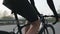 Cyclist riding a bicycle and changing gears. Close up follow shot. Cyclist pedaling on bicycle in motion. Slow motion