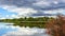 Cyclist riding a bicycle on the Sava river bank, with some dramatic sky at spring time