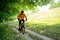 Cyclist Riding the Bike on the Trail in the Forest