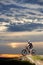 Cyclist in sportswear and helmet sitting on bike.