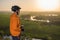 Cyclist at sunset in the mountains. A young man in a helmet and glasses drinks water from a bottle.