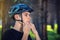 Cyclist is wearing a sports helmet on his head in the background of green nature. Mandatory protection during Cycling