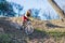 Cyclist in a yellow sweater and red shorts sliding off the cliff, a copy of the space