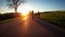 Cyclists cycling on mountain road in sunset lights