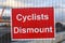 Cyclists Dismount sign next to a construction site