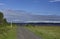 Cyclists heading down a gravel path on the Fife Coastal Path near to Tentsmuir Nature Reserve with a waypoint marker.