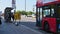 Cyclists and a person on an electric scooter ride along the road on Waterloo Bridge next to a bus stop, followed by a Red London