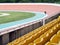 cyclists practicing cycling in bicycle race track with vacant yellow stadium grandstand seats