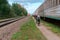 Cyclists ride along the railway, tourists on bicycles near the train