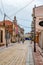 Cyclists ride on Rruga G`juhadol pedestrian street in Shkoder, vertical. Ancient architecture