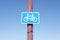 Cyclists riding road highway lane warning sign post blue sky background information