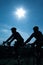 Cyclists silhouette under sun