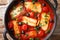 Cyprus food baked Halloumi with tomatoes, peppers, olives in a spicy sauce close-up in a pan. Horizontal top view