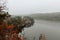 Czech autumn foliage trees landscape with small island on Rimov dam in misty fog