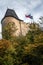 Czech Flag waiving on main medieval dungeon of Hrad Karlstejn castle during an autumn afternoon. Karlstejn is a gothic castle