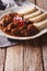 Czech Food: goulash with knedle on the table close-up. vertical