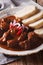 Czech Food: Traditional goulash with dumplings macro. vertical