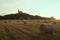 Czech middle age castle Kuneticka Hora with bales of hay and sunset - harvest at the end of summer (Pardubice)