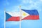 Czech and Philippines two flags on flagpoles and blue cloudy sky