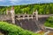 Czech republic, Talsperre Les Kralovstvi Forest Kingdom - May 15, 2021. Historic hydraulic water dam with orange water in river