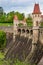 Czech republic, Talsperre Les Kralovstvi Forest Kingdom - May 15, 2021. Historic hydraulic water dam with orange water in river
