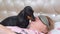 Dachshund dog tries to wake up female owner in bedroom