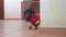 Dachshund puppy in red costume walks from behind corner