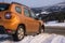 Dacia Duster SUV at the exit of the snowy mountain wilderness on the asphalt path