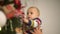 Dad and baby decorates the Christmas tree. Happy family celebrates Christmas together. Slow motion.