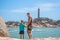 Dad care Son near sea, walk spend time together explore new. Man hold kid hand. Lighthouse background Symbol of