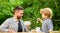 Dad and cute toddler boy having lunch outdoors. Child care. Feeding son natural foods. Feed in right way for childs