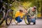 Dad and daughter inspect wheel of children`s teenage bicycle on the autumn path of the park