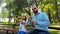 Dad and daughter are launching soap bubbles in park.