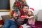 Dad and daughter near the Christmas tree with a smartphone take a selfie, communicate via video connection. Christmas greetings, a